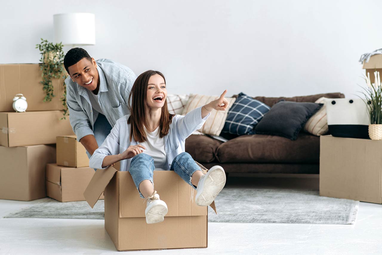 Happy mixed race young family couple, bought their own house, they having fun on moving day