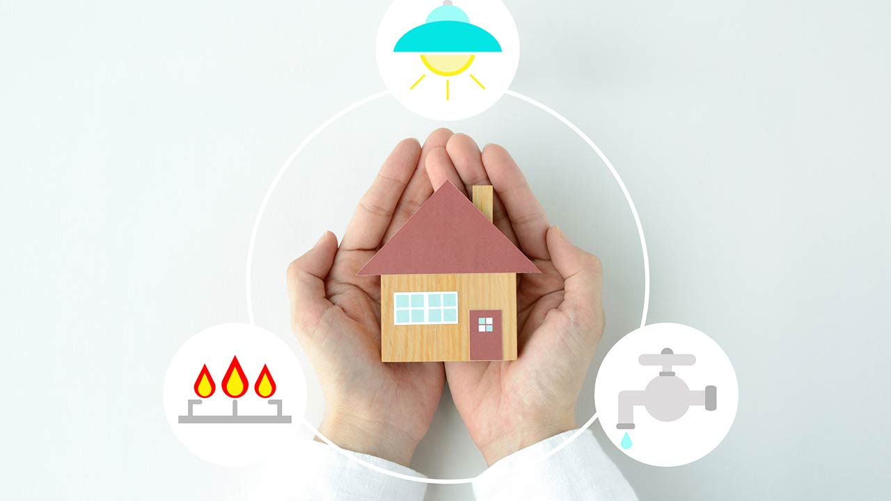 Human's hands and house object with gas, electricity and water icons