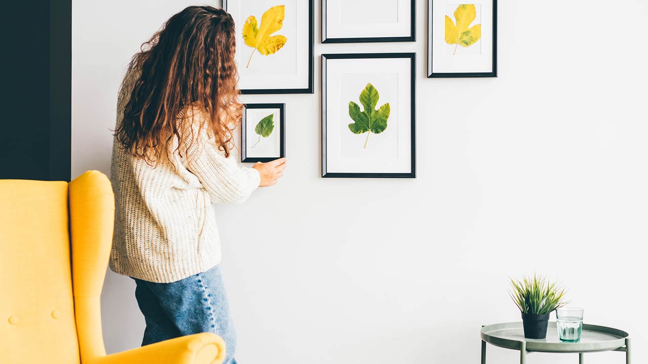 Younger woman restoring old furniture with sandpaper