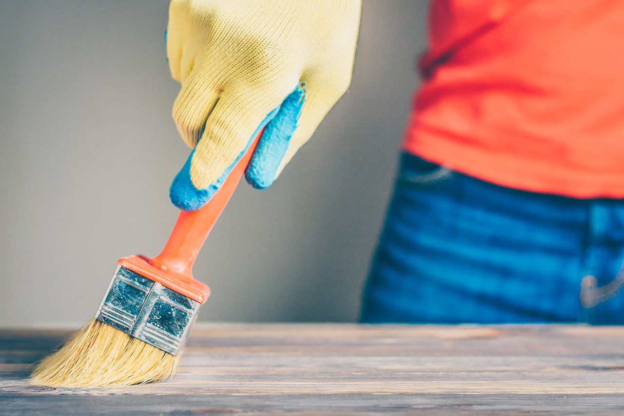 Waxing and oiling with a brush on a wooden table